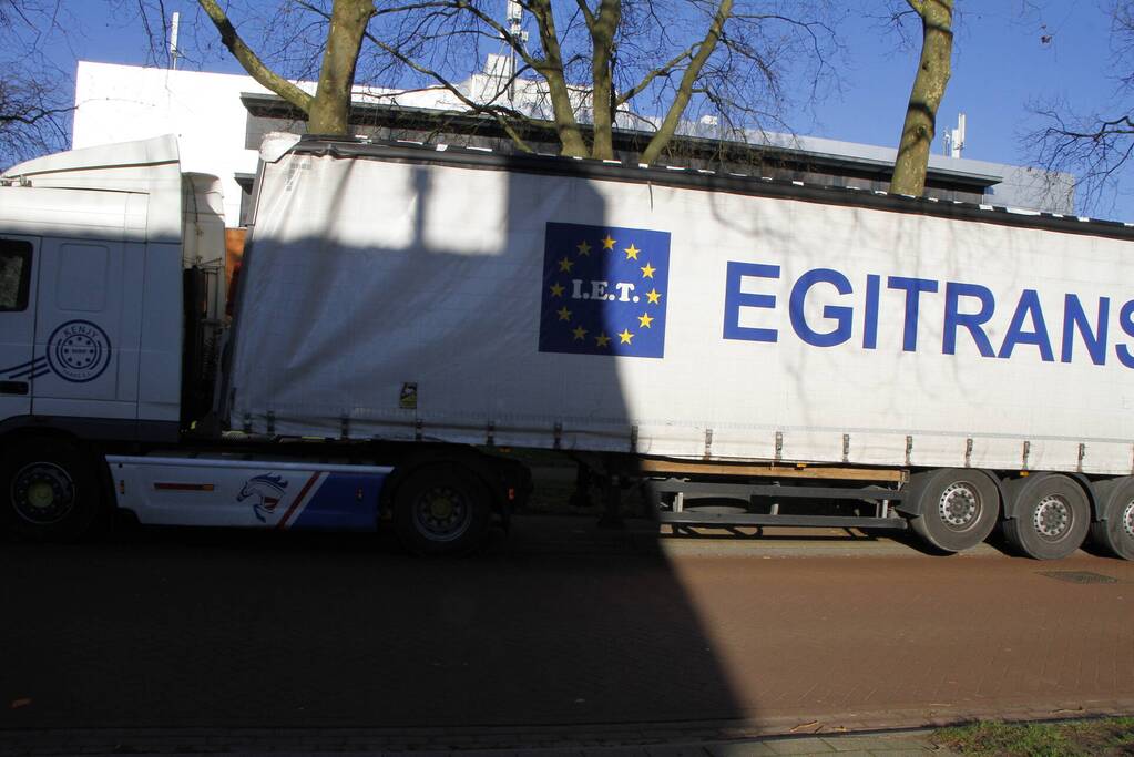 Vrachtwagen rijdt met oplegger tegen spoorbrug