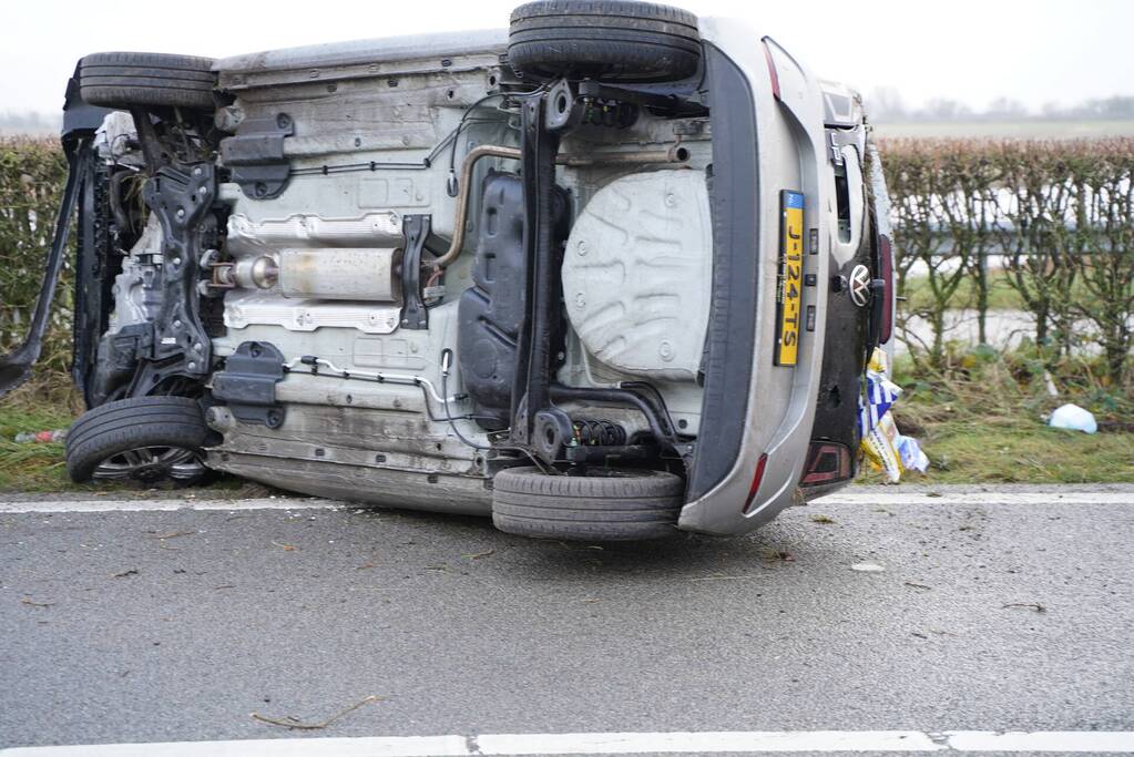 Auto op zijn kant bij verkeersongeval