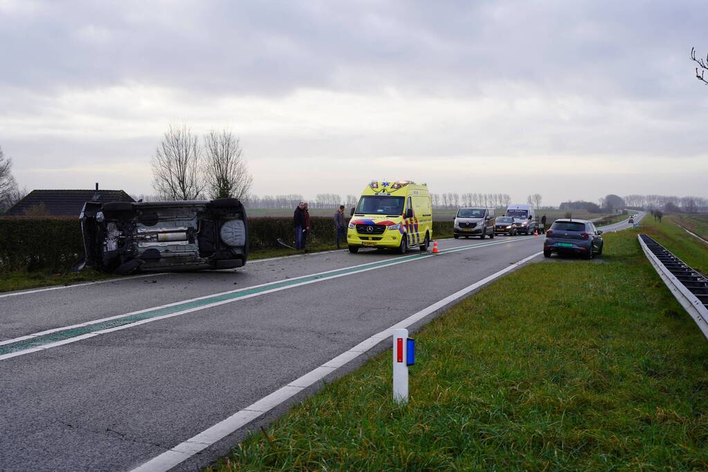 Auto op zijn kant bij verkeersongeval