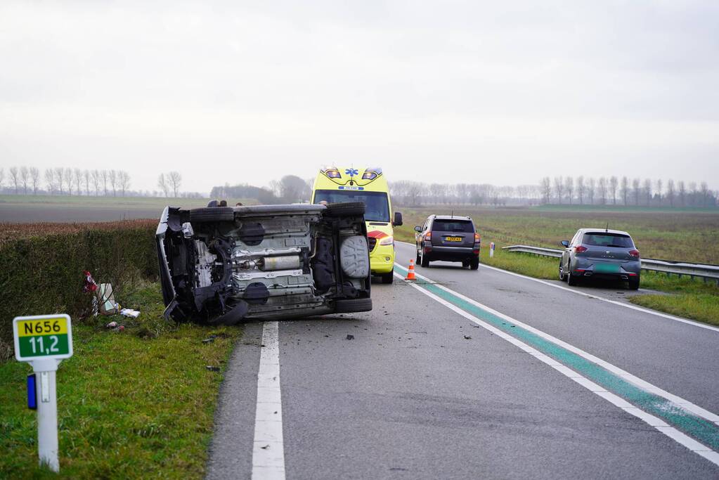 Auto op zijn kant bij verkeersongeval