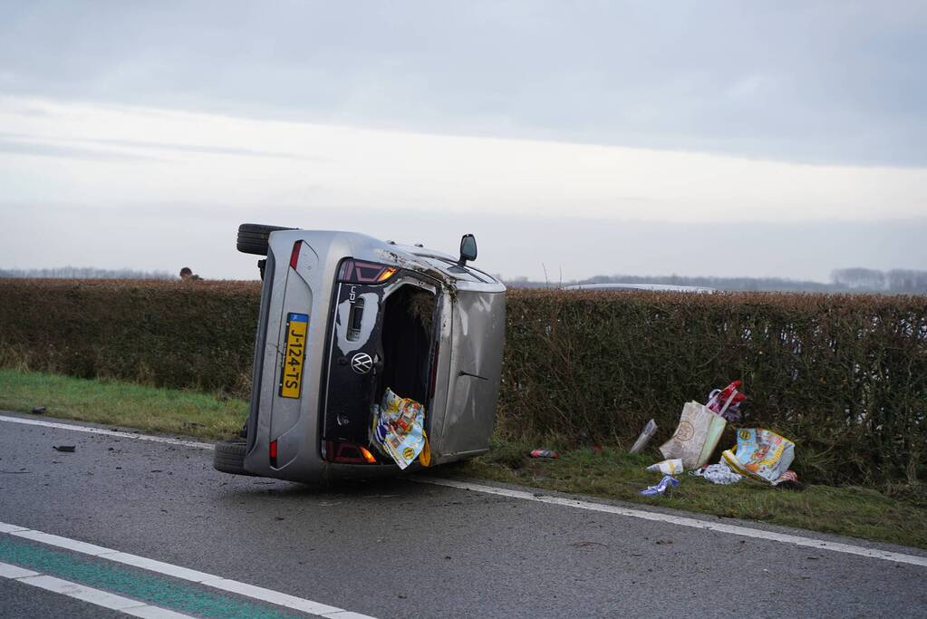 Auto op zijn kant bij verkeersongeval