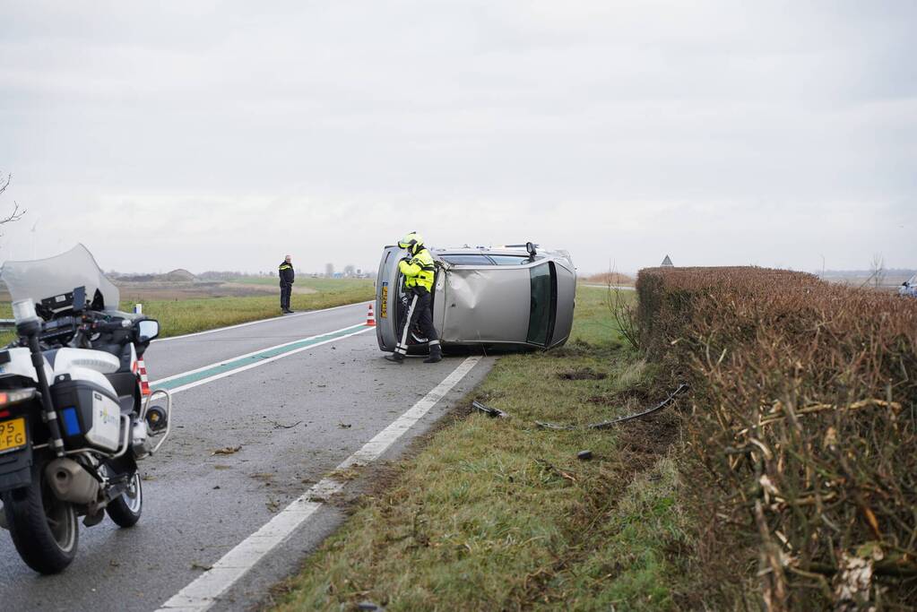 Auto op zijn kant bij verkeersongeval