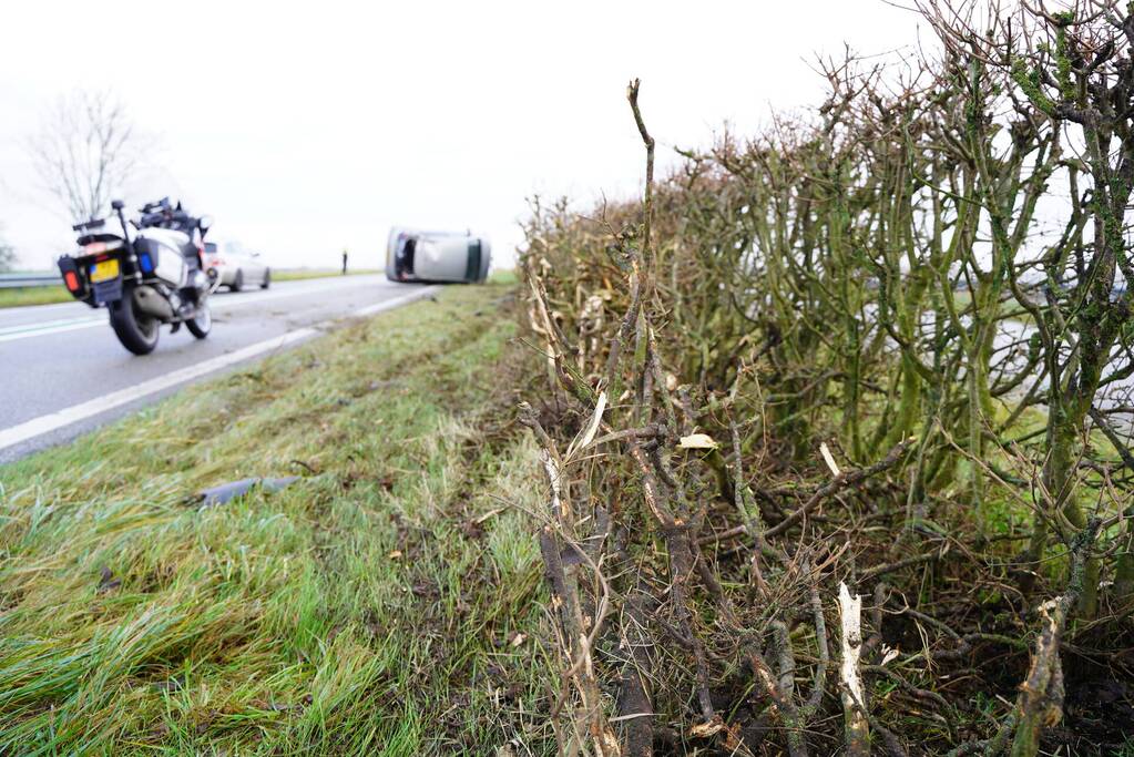 Auto op zijn kant bij verkeersongeval