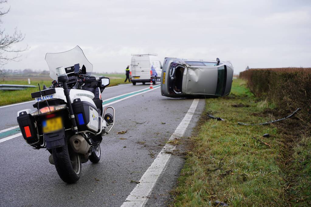 Auto op zijn kant bij verkeersongeval