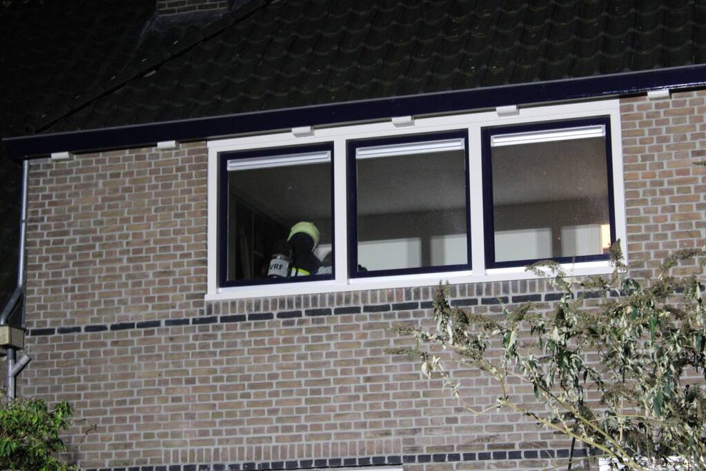 Brandweer breekt schoorsteen open na brandlucht