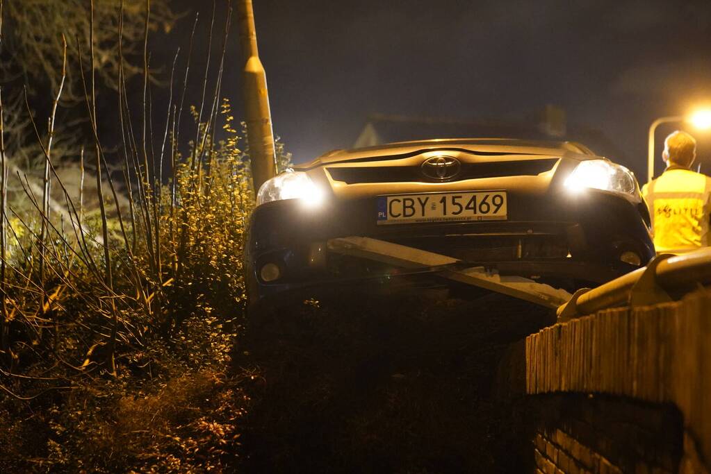 Auto belandt op betonnen muur van de brug