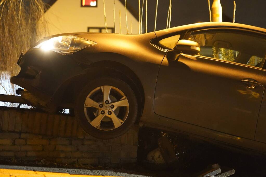 Auto belandt op betonnen muur van de brug