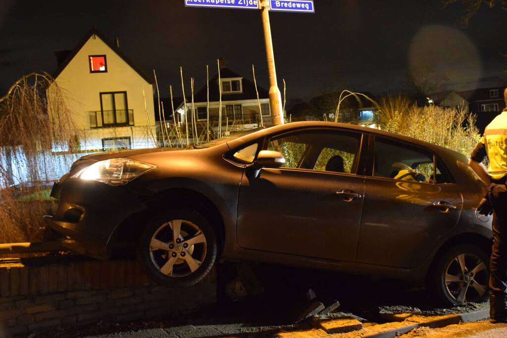 Auto belandt op betonnen muur van de brug