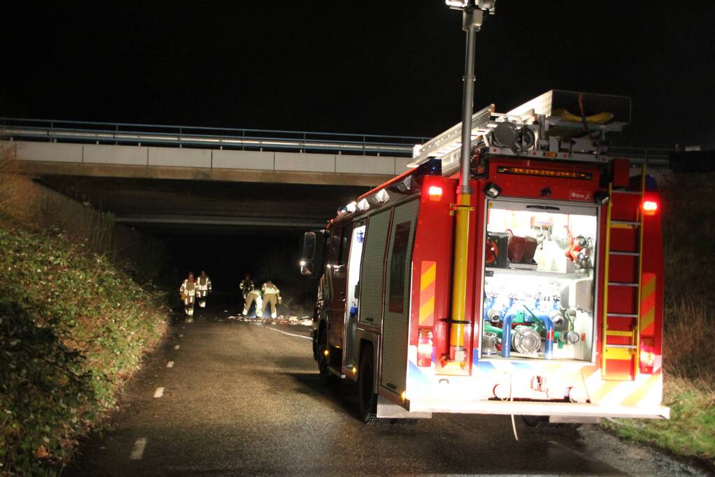 Stapel afval in brand onder brug over snelweg
