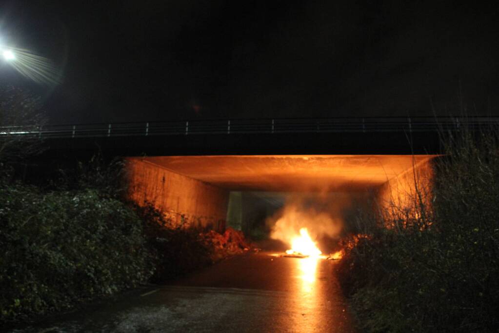 Stapel afval in brand onder brug over snelweg