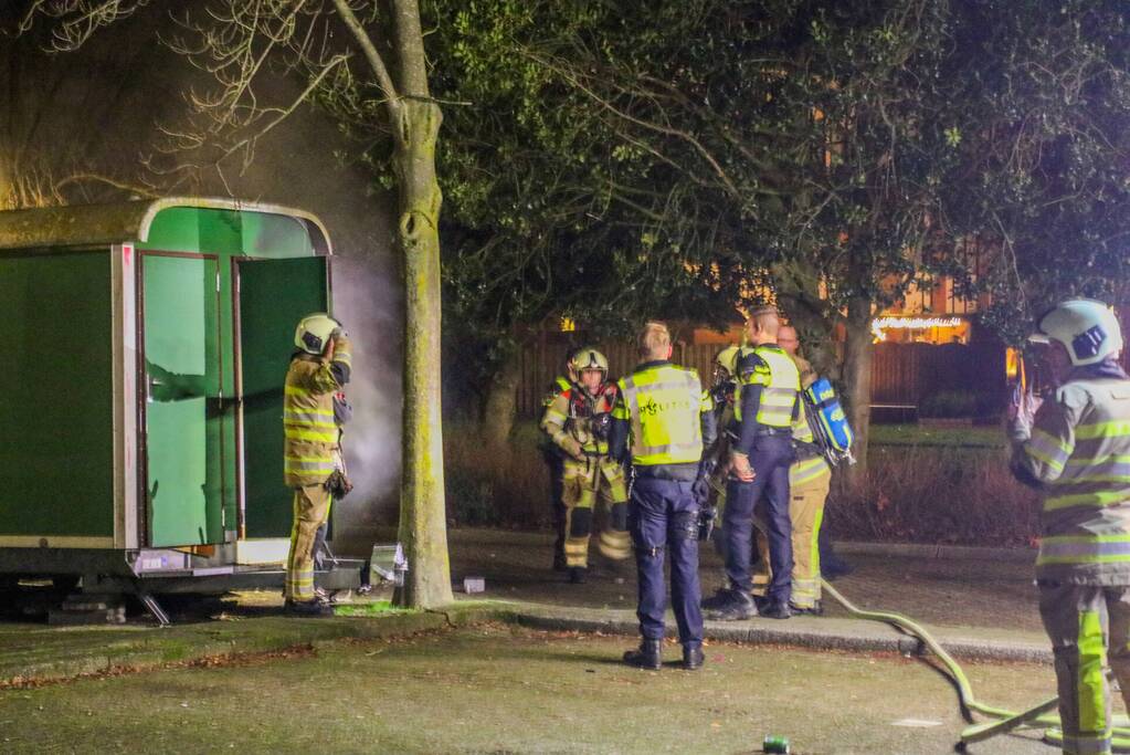 Brandweer blust brand in bouwkeet