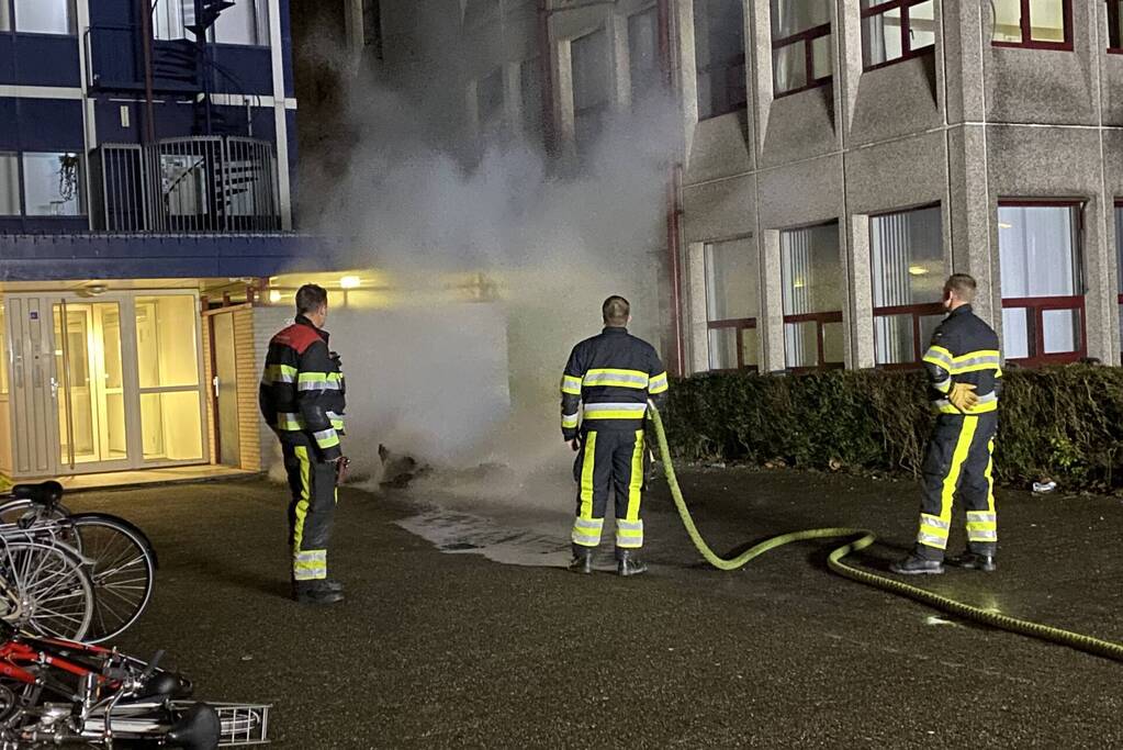 Container in brand tegen gebouw