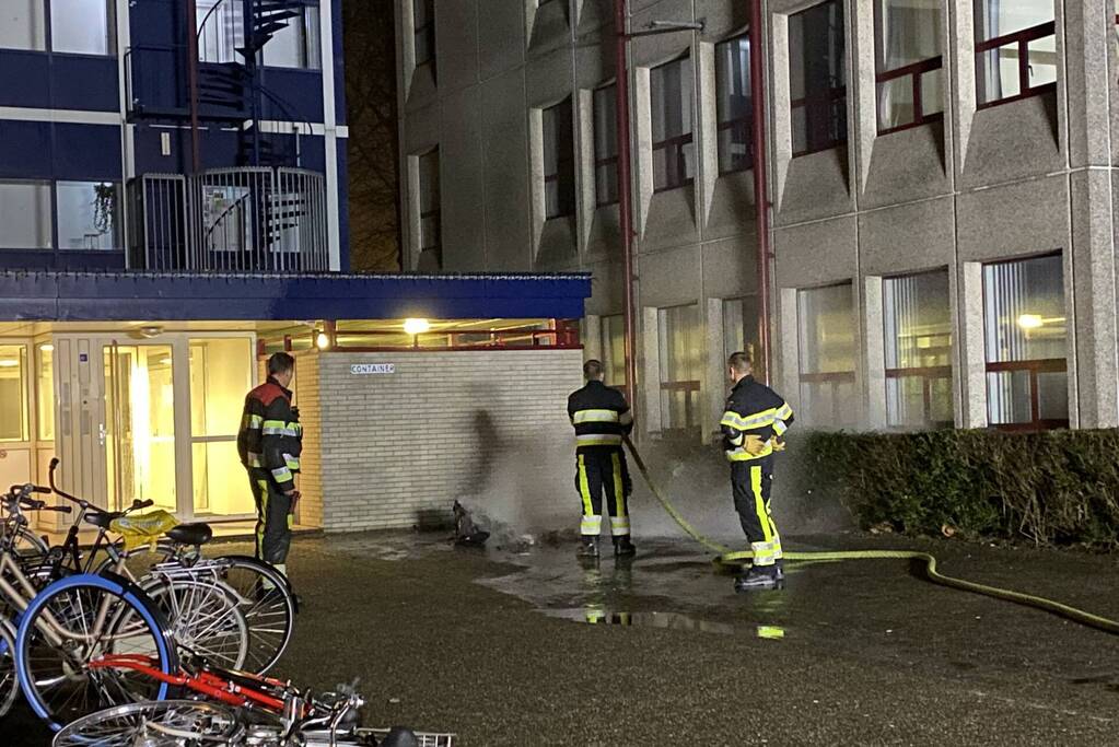 Container in brand tegen gebouw