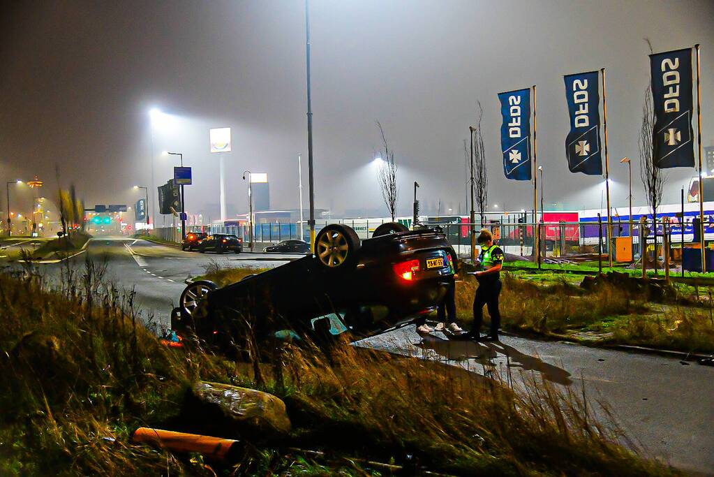 Auto vliegt uit de bocht en belandt op op zijn kop