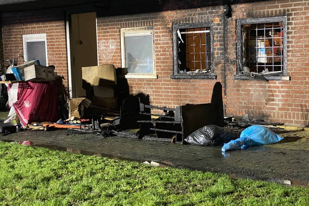 Bank in brand onder balkon van flat