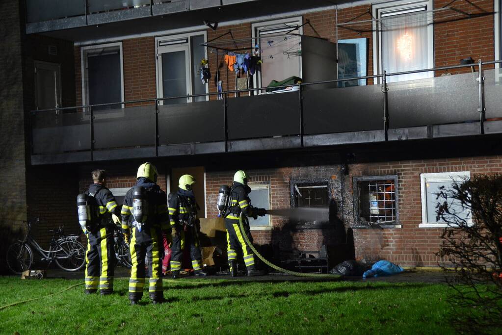 Bank in brand onder balkon van flat