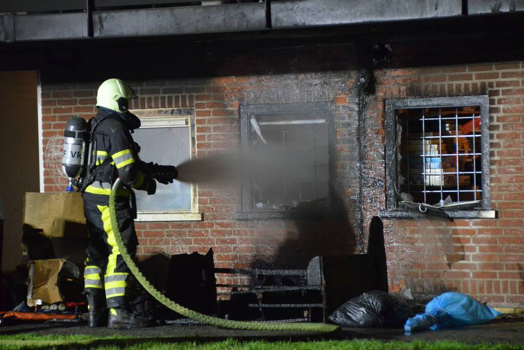 Bank in brand onder balkon van flat