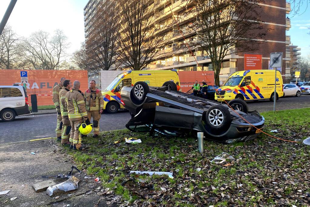 Auto ramt lantaarnpaal en slaat over de kop