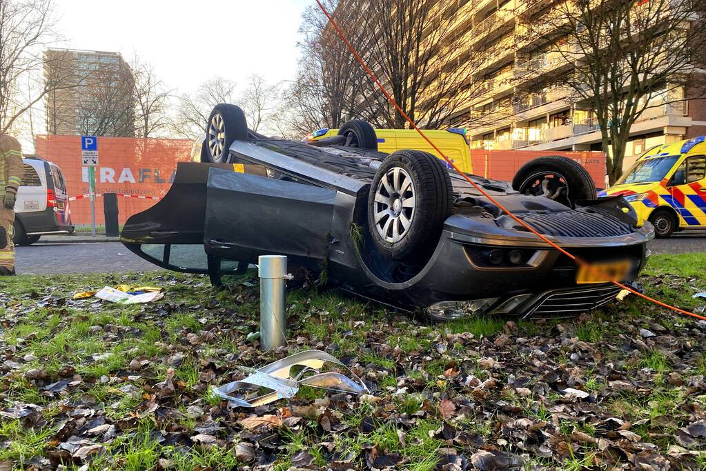 Auto ramt lantaarnpaal en slaat over de kop