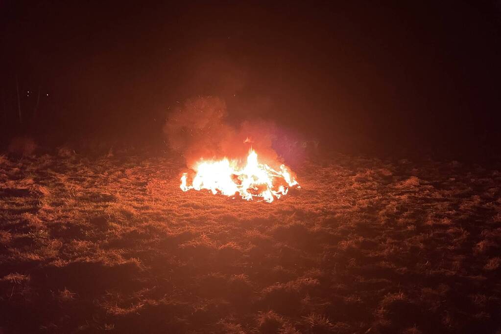 Brandweer blust brandende hoop afval