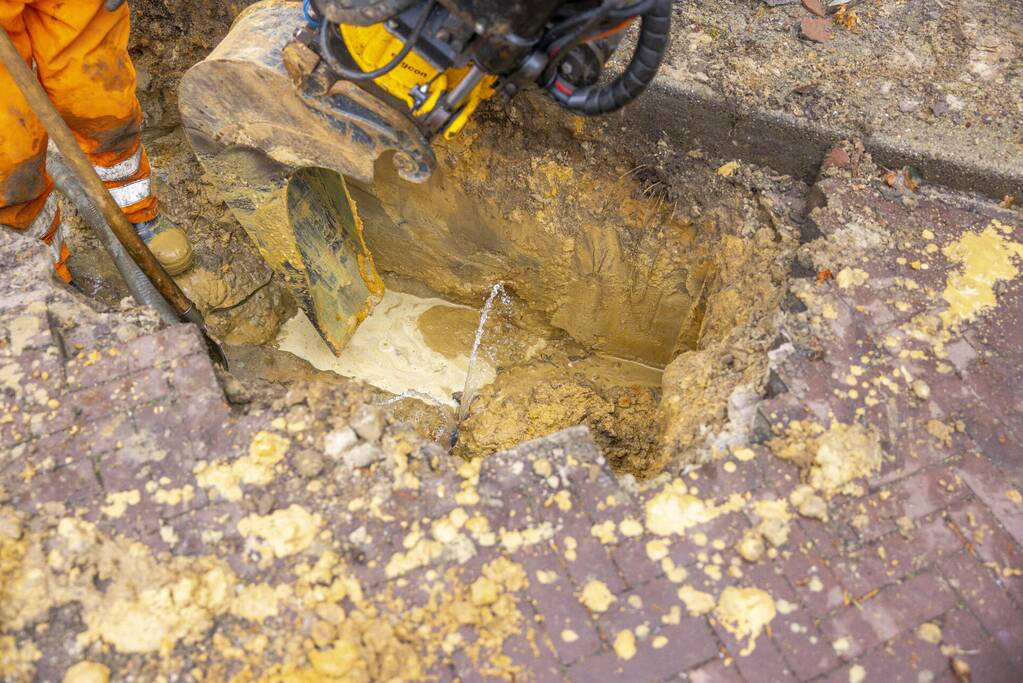 Straat opengebroken door waterlekkage