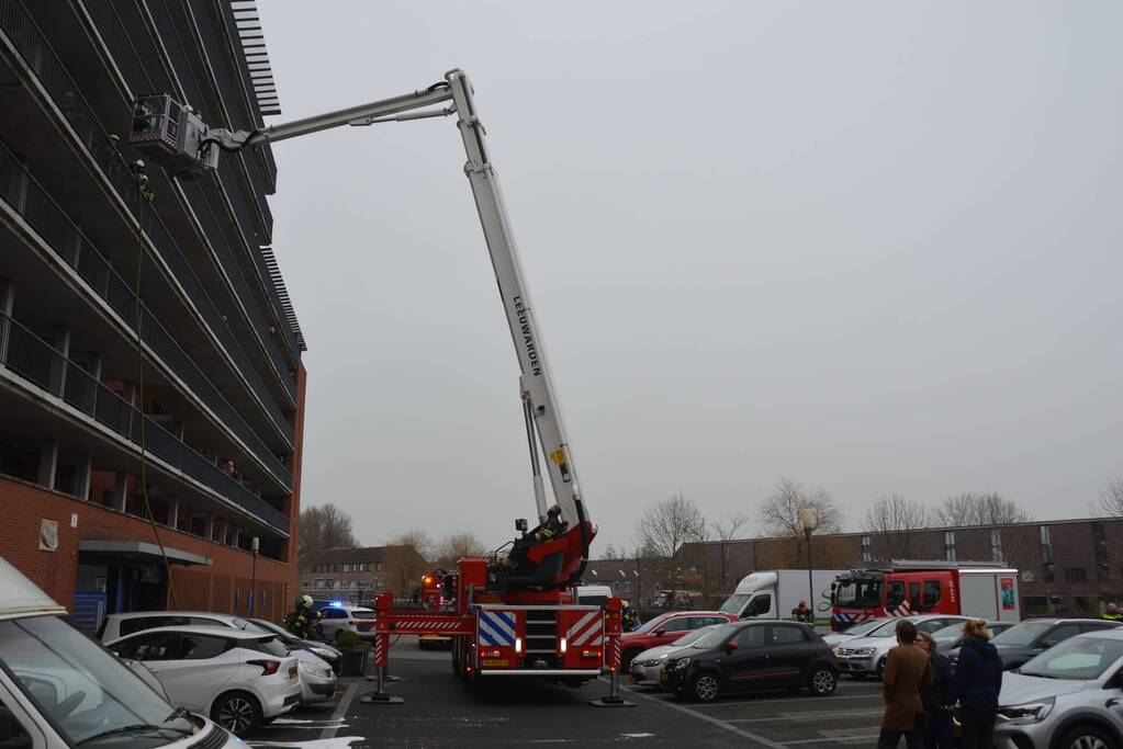 Zwarte rookwolk bij brand in flatwoning