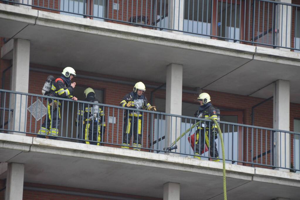Zwarte rookwolk bij brand in flatwoning