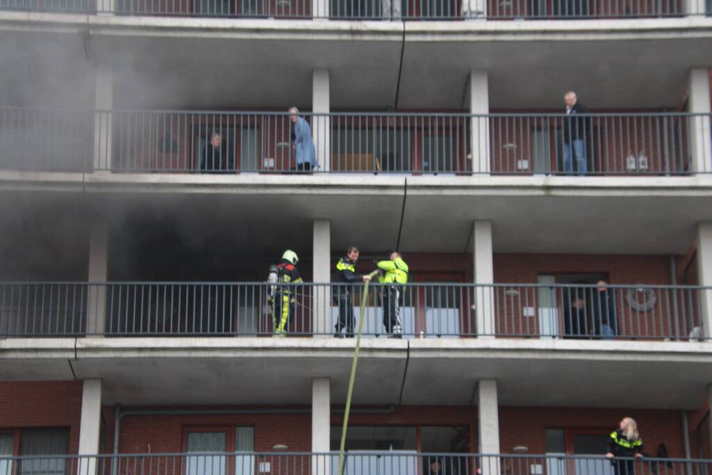 Zwarte rookwolk bij brand in flatwoning