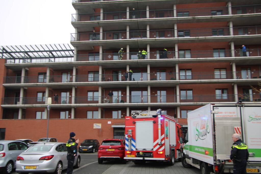 Zwarte rookwolk bij brand in flatwoning