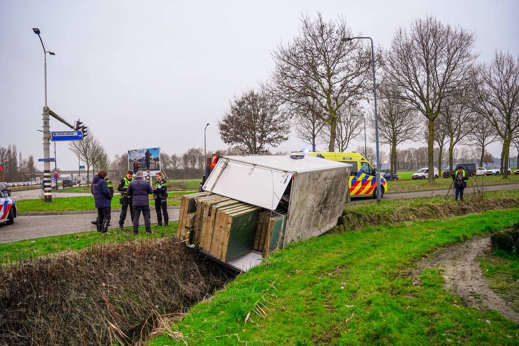 Bestelbus kantelt en belandt in sloot