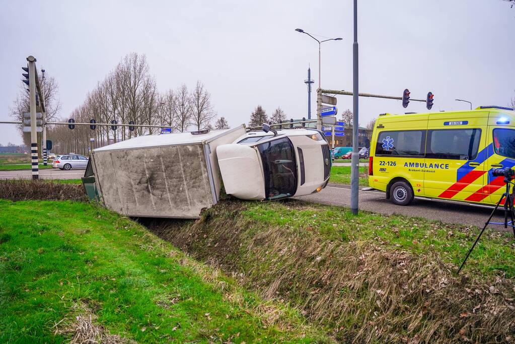 Bestelbus kantelt en belandt in sloot