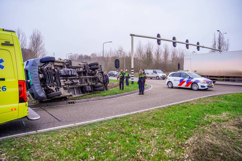 Bestelbus kantelt en belandt in sloot
