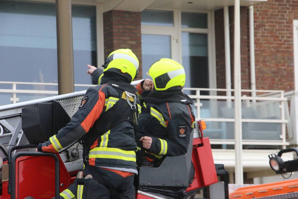 Brandweer verwijderd dakplaten en zet dakgoot vast