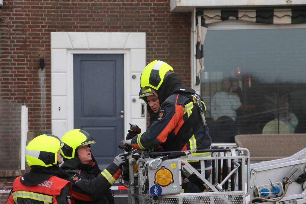 Brandweer verwijderd dakplaten en zet dakgoot vast