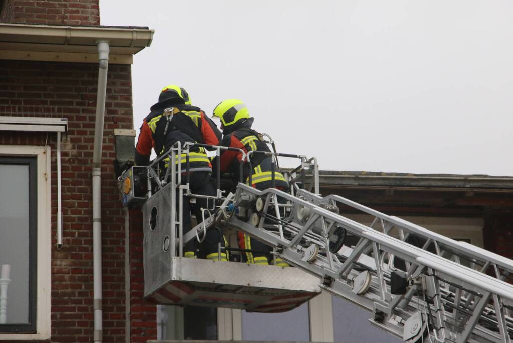 Brandweer verwijderd dakplaten en zet dakgoot vast