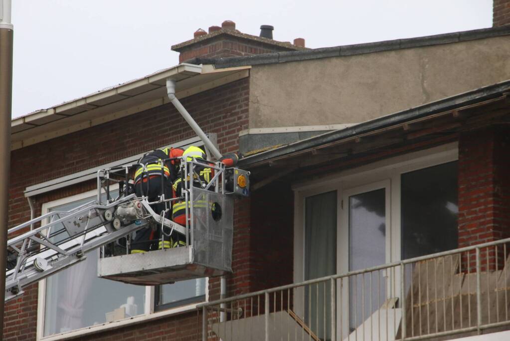 Brandweer verwijderd dakplaten en zet dakgoot vast