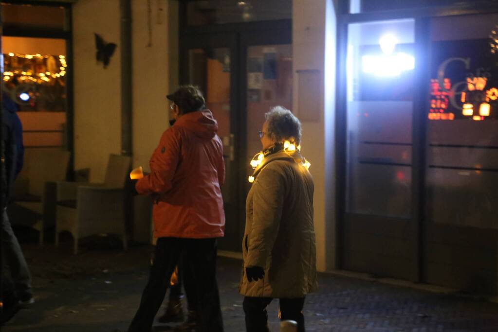 Groep mensen loopt lichtjestocht tegen coronamaatregelen