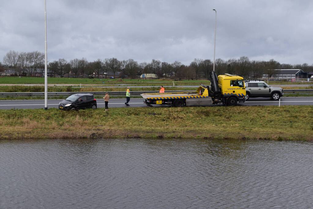 Auto raakt in slip op afrit