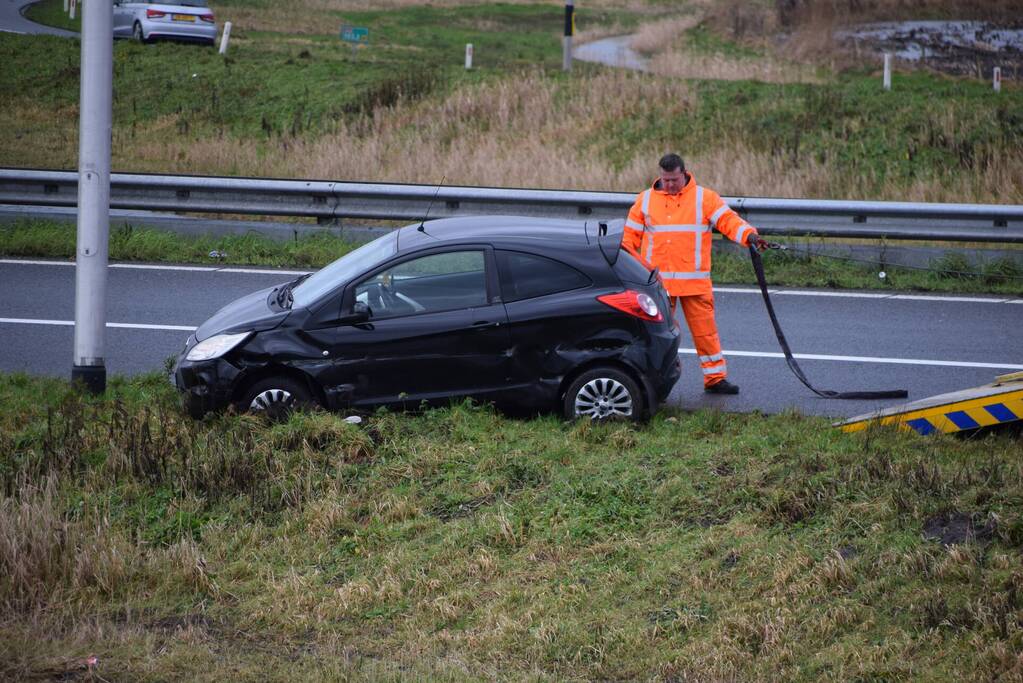 Auto raakt in slip op afrit
