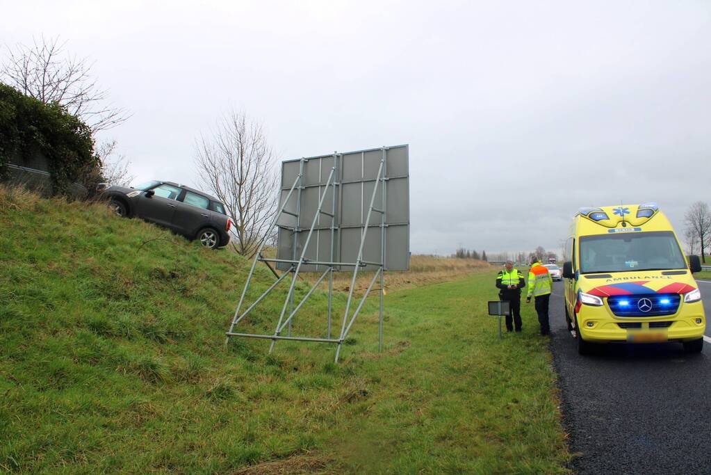 Automobilist raakt van de weg belandt boven op geluidswal