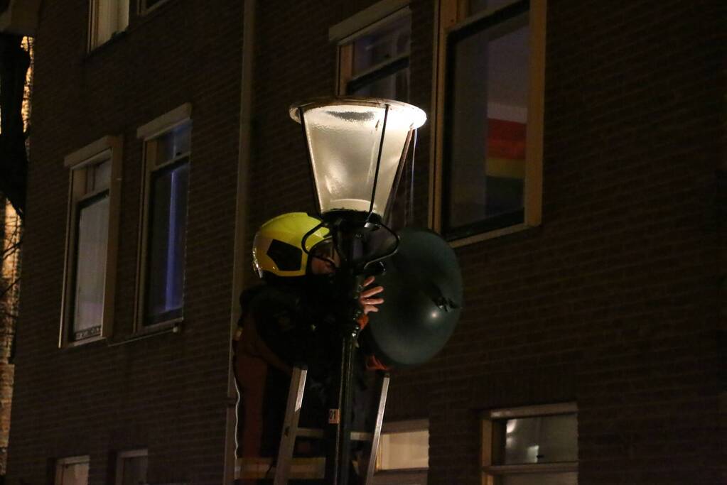 Brandweer haalt losse kap van lantaarnpaal