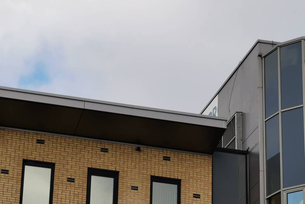 Bedrijfsbord waait los van kantoorpand