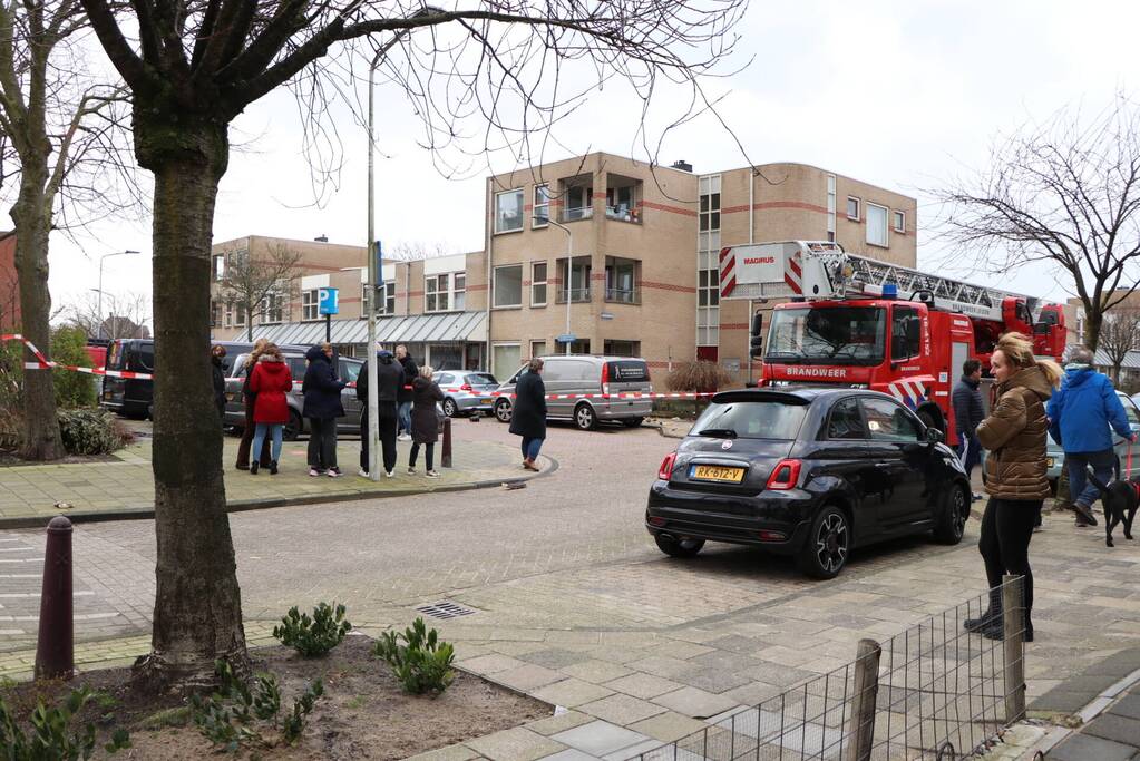 Dakbedekking van flat waait over auto's en lantaarnpalen