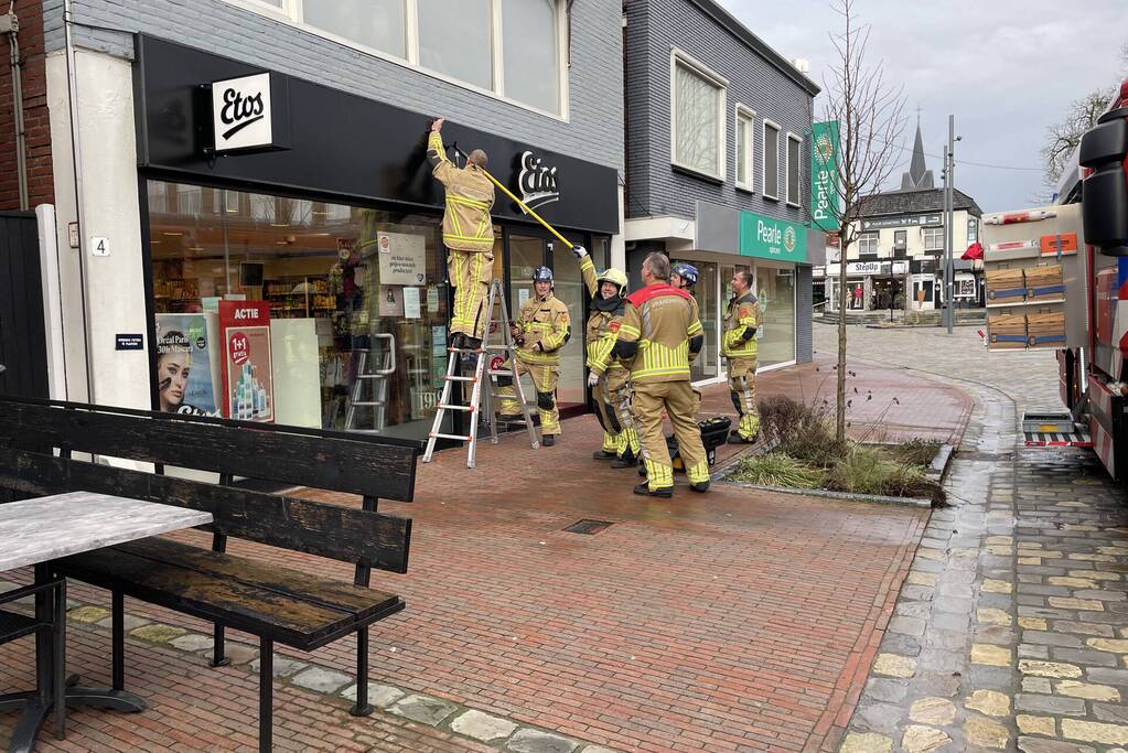 Gevelplaten van winkel laten los door harde wind