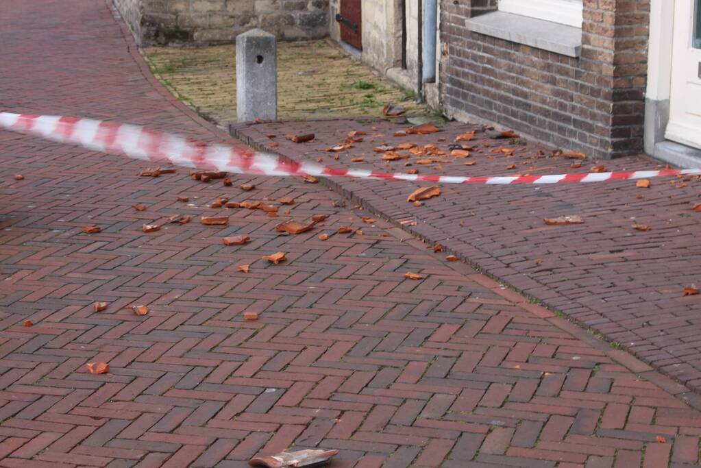 Dakpannen waaien van woning