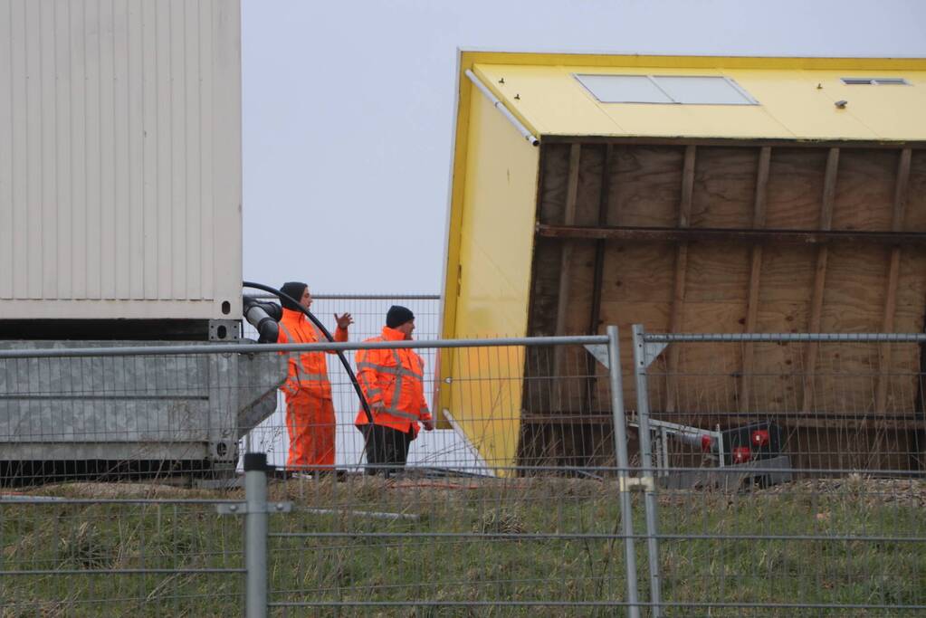 Bouwkeet waait om en belandt op wegdek