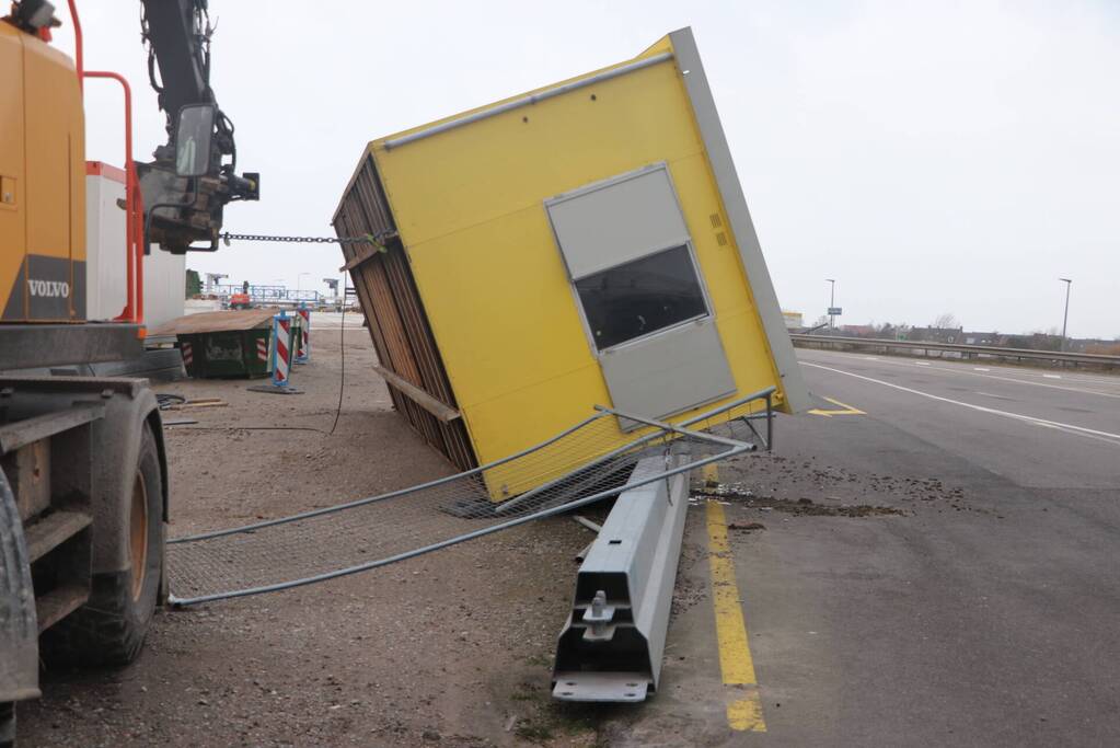 Bouwkeet waait om en belandt op wegdek