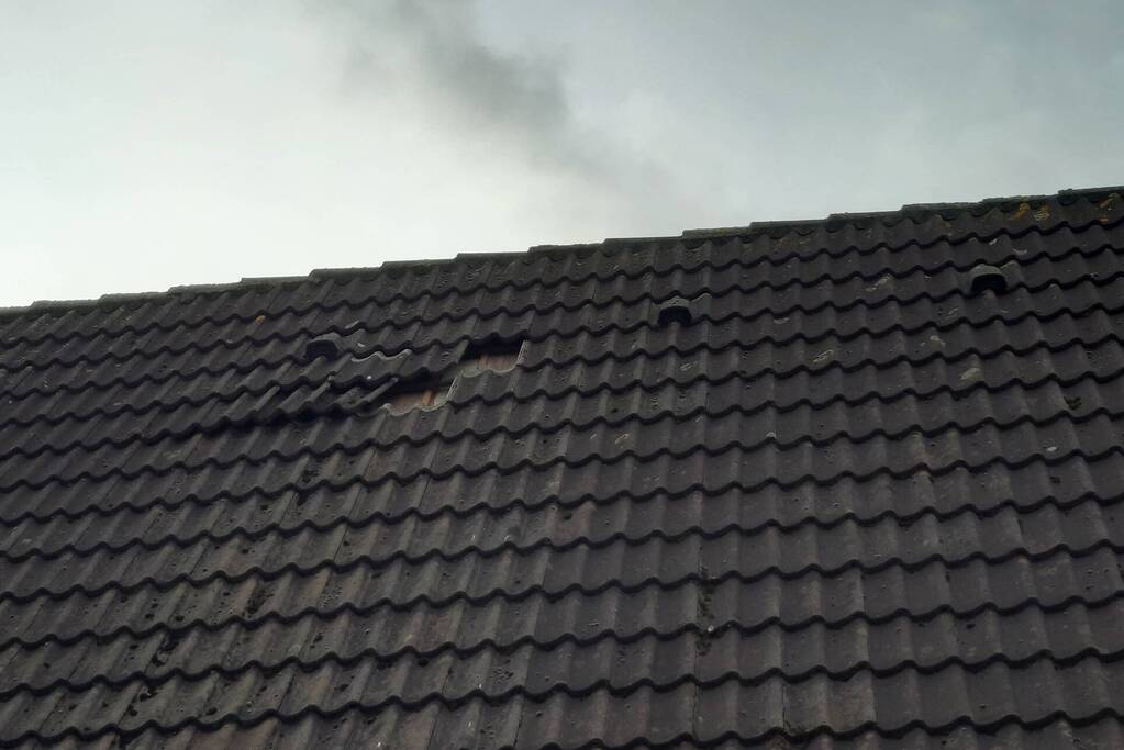 Brandweer plaatst dakpannen terug op woning