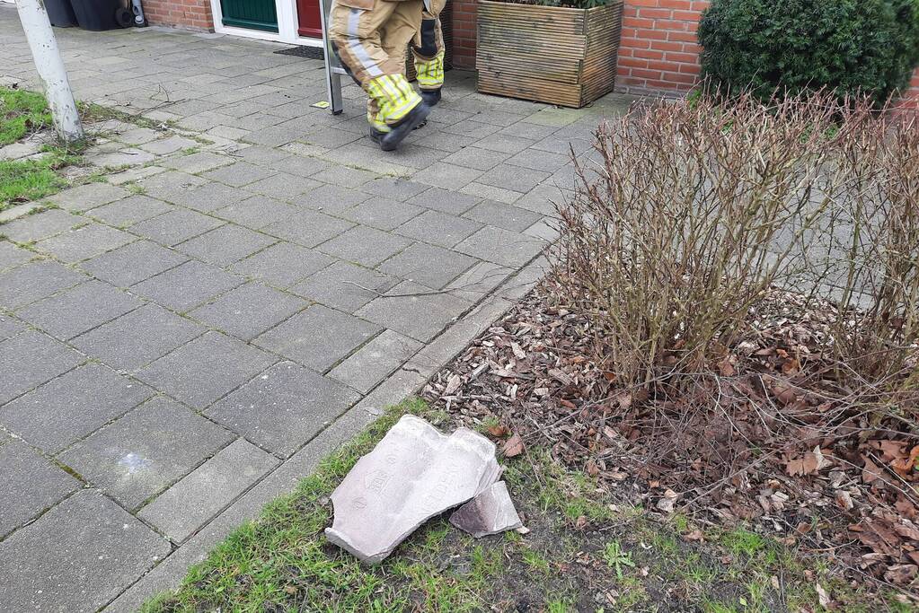 Brandweer plaatst dakpannen terug op woning
