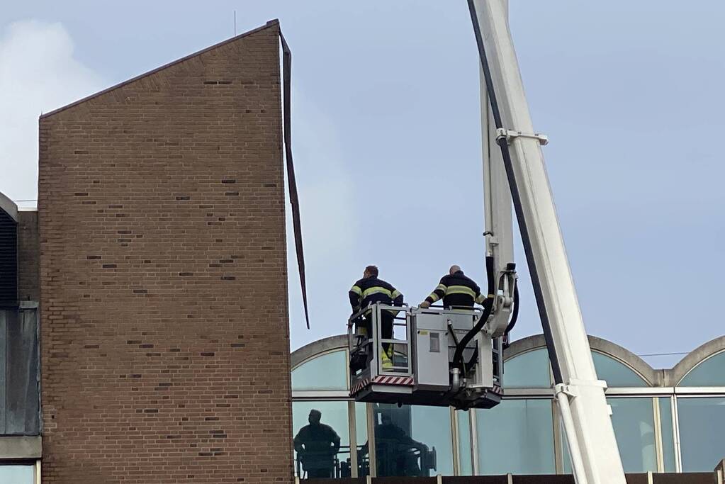 Brandweer verwijderd losgekomen dakbedekking
